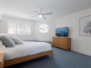 士兵点Pelican Sands 3 stunning waterfront unit with magical water views and air conditioning的一间卧室配有一张床和吊扇