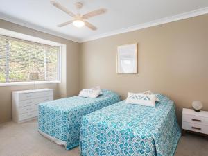 尼尔森湾Serenity Peaceful house with air con Netflix and WI-FI的一间卧室设有两张床和窗户。