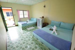 达叻府Mukda Guesthouse的一间卧室配有一张白色玩具的床