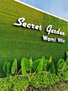 麻坡Secret Garden Warni Villa (MUAR)的花园公司前面有植物的标志