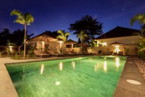 塞隆贝拉纳克Green Valley Lombok的夜间在房子前面的游泳池