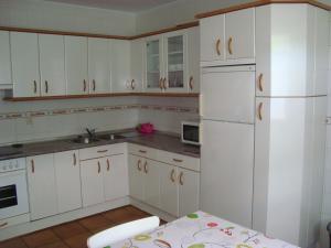 GarzáinLOPENEA的厨房配有白色橱柜和白色冰箱。