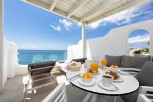 德里奥斯Blue Waves Suites & Apartments - To Kyma的一张桌子,在阳台上提供早餐食物,阳台上享有海景