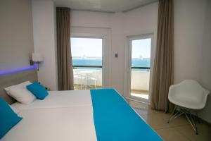 拉纳卡Les Palmiers Beach Boutique Hotel & Luxury Apartments的一间卧室配有一张床,享有海景