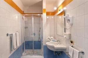 索伦托布里斯托尔酒店的一间带玻璃淋浴和水槽的浴室