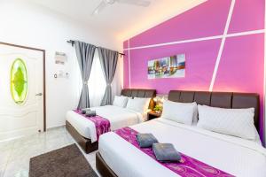 珍南海滩Cenang Rooms With Pool by Virgo Star Resort的紫色墙壁客房的两张床