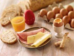 阿布维尔宜必思阿布维尔酒店的一张桌子,上面放着一盘奶酪,鸡蛋和面包