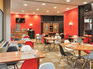 勒布伊勒皮宜必思酒店 - 勒皮昂沃莱中心的一间带桌椅和红色墙壁的餐厅