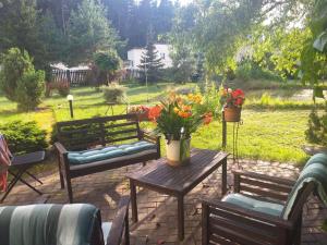 DreiliņiGuest House Pechersky & Sons的庭院设有2张长椅和鲜花桌。