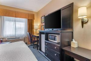 梅德福Clarion Pointe Medford的配有一张床和一台平面电视的酒店客房