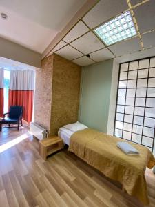 塔林Majaka Hostel的一间卧室配有一张床、一把椅子和窗户。