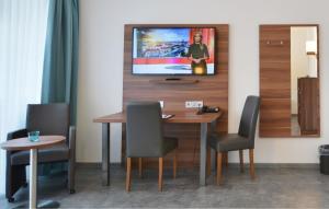 海德堡新海德堡公寓旅馆的餐桌、椅子和墙上的电视