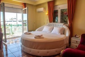伊古迈尼察阿斯托里亚酒店的一间卧室配有一张大床和毛巾