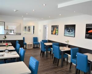 斯图加特Hotel BaWü的一间配备有蓝色椅子和桌子的用餐室