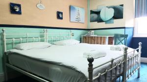 温德米尔温德米尔湖旅馆的卧室配有白色床和蓝色的墙壁