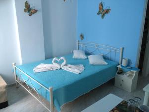 阿吉亚利Aegeon Pension的蓝色卧室配有带毛巾和蝴蝶的床