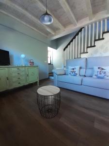 里瓦德塞利亚La Vierta Casa Rural Agroturismo的客厅设有蓝色的沙发和楼梯。