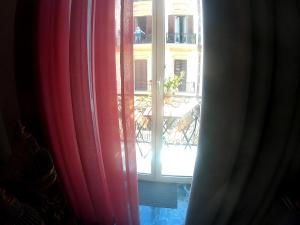那不勒斯B&B Lex Room Santa Lucia的阳台的窗户享有红色窗帘的景致。