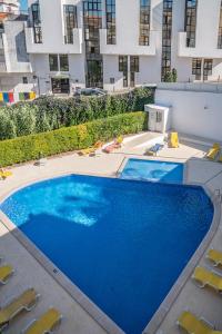 阿尔布费拉Garden Hill Apartment的一座带椅子的大型蓝色游泳池和一座建筑