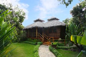 邦劳Donatela Resort and Sanctuary的一个带草屋顶的小小屋