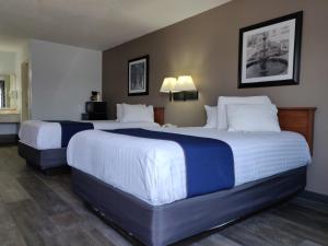 桑达斯基Cedar Cove的酒店客房带两张床,带白色和蓝色的床单