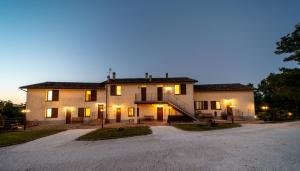 SassoferratoAgriturismo Podere Coldifico的前面有车道的大房子