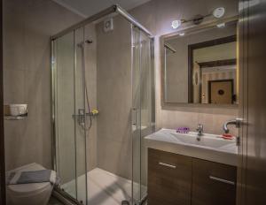 罗希姆诺西奥海滩酒店式公寓的带淋浴和盥洗盆的浴室