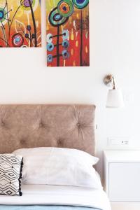 杜布罗夫尼克Orsan Residence的卧室配有一张床,墙上挂有绘画作品