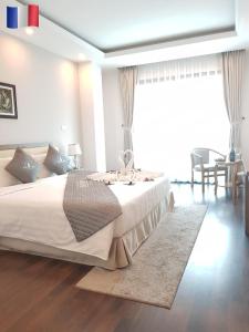 河内朝圣酒店的卧室配有一张大白色的床和地毯