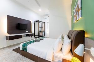 珍南海滩Cenang Rooms With Pool by Virgo Star Resort的卧室配有一张床铺,墙上配有电视