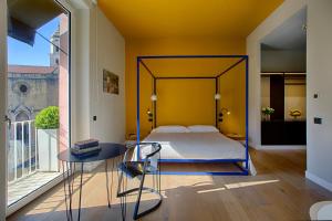 那不勒斯Casa Pacifico Napoli的一间卧室配有一张床、一张桌子和一个窗户。