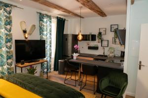滨海萨纳里studio coeur de ville neuf et design tt equipé parking gratuit的客厅设有厨房和带电视的书桌
