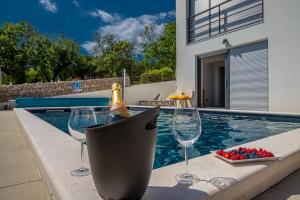 诺维·维诺多尔斯基Apartment Di Blu的游泳池旁的一瓶香槟和酒杯