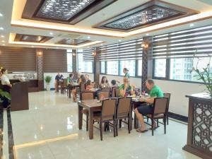 河内T&M Luxury Hotel Hanoi的一群坐在餐厅桌子上的人