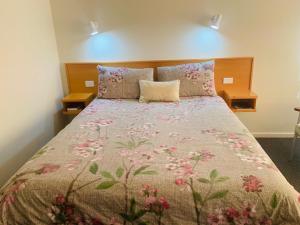 格伦因尼斯安娜贝拉格伦斯尼斯汽车旅馆的一间卧室配有一张带花卉床罩的床