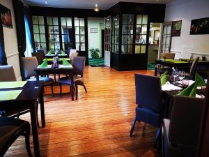 巴尼奥勒德日洛恩布里特茶花酒店的一间带桌椅的餐厅,铺有木地板