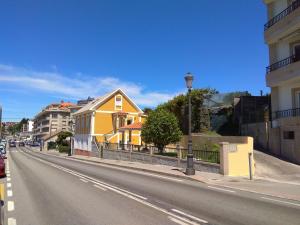 桑亨霍Casa Marisma Xacobeo的街道边的黄色房子