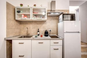罗马Novembre 152 Apartment的厨房配有白色橱柜和白色冰箱。
