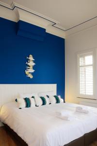 哈勒De Kaai的一间卧室配有一张白色大床和蓝色的墙壁