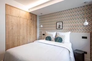 巴黎NEW - Superbe 1 Bdr Appt - Design 60'S - Paris 15e的卧室配有白色的床和木墙