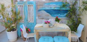 斯基亚索斯镇Hotel Kastro的一个带桌椅的庭院和一扇蓝色的门