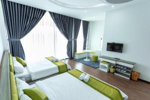 绥和市Khách sạn Minh Anh的酒店客房设有两张床和电视。
