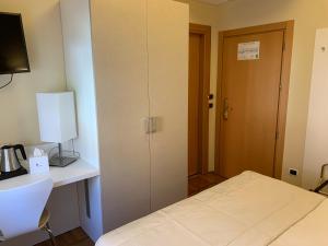 梅纳焦贝拉维斯塔酒店的一间设有床铺、书桌和门的房间