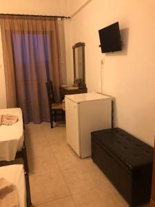 欧拉努波利斯Hotel Avra的一间设有冰箱和墙上电视的客房