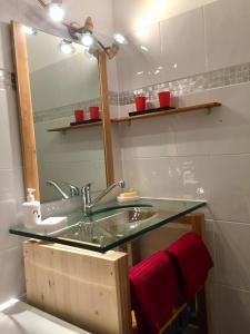 维拉尔-德朗Studio pied des pistes的一间带玻璃水槽和镜子的浴室