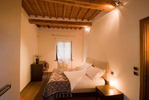 蒙特普齐亚诺维可罗德洛斯特酒店的一间卧室配有一张带白色床单的床和一扇窗户。