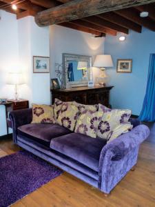 哈罗盖特时瑞赛巴诺公寓的客厅配有带镜子的紫色沙发