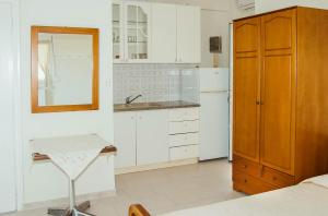 卡梅纳维洛拉RONZI APARTMANT的厨房配有白色橱柜、水槽和镜子