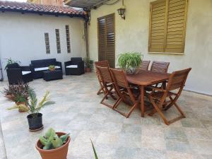 NaroLa Fenice apartment的种有植物的庭院里摆放着木桌和椅子