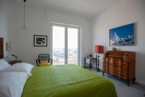 那不勒斯B&B ICHOME NAPOLI - Maison d'Artiste的一间卧室设有一张绿色大床和一个窗户。